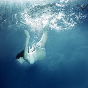 Pregnant woman swimming under water 