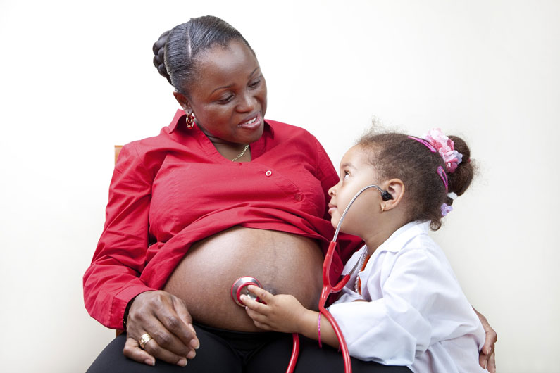 pregnant woman and child listening to baby