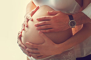 pregnant couple touching belly